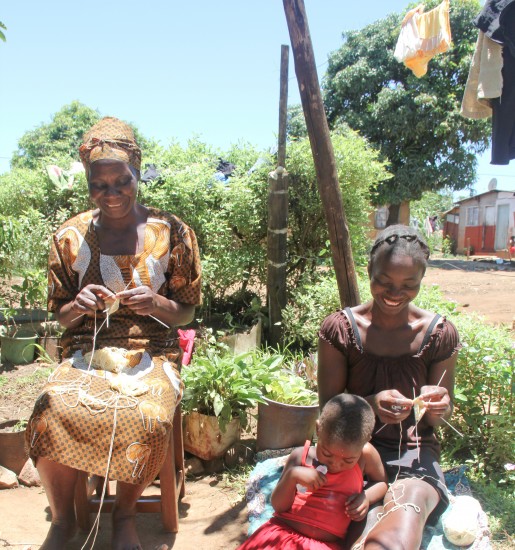 Global Mothers mother/daughter artisans, Alice and Mercy, knitting finger puppets in Zimbabwe